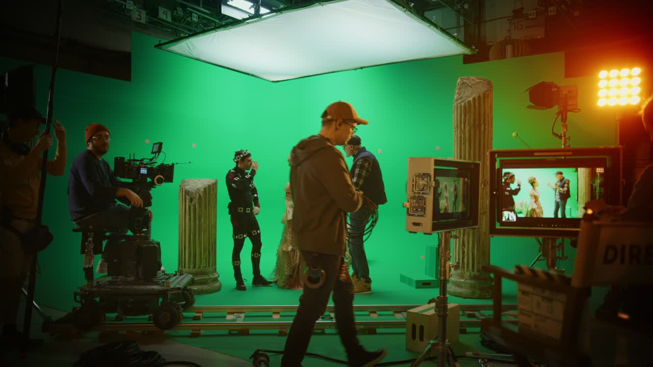en el set: el director explica la escena a la actriz que juega a la dama del renacimiento y el actor que usa un traje de captura de movimiento. en el gran estudio de cine, la tripulación profesional dispara una película de drama de vestuario de época.