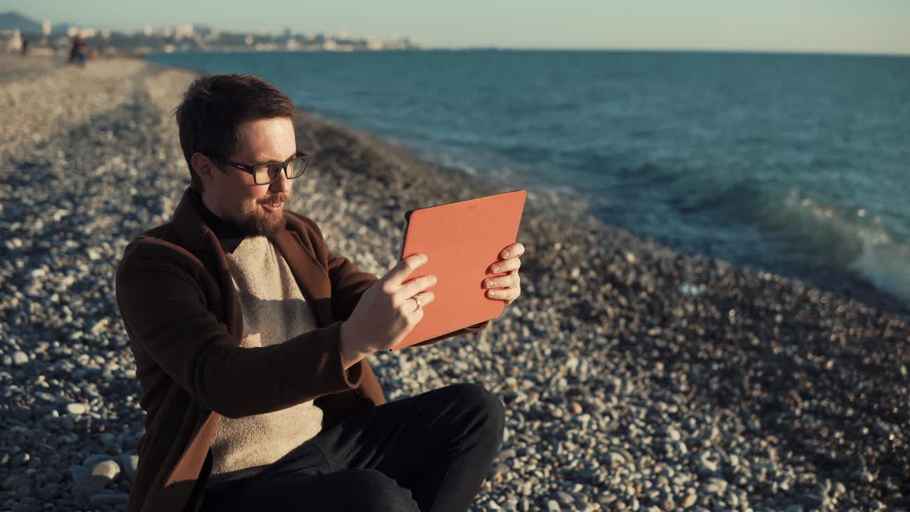hombre tomando una llamada de video en la playa