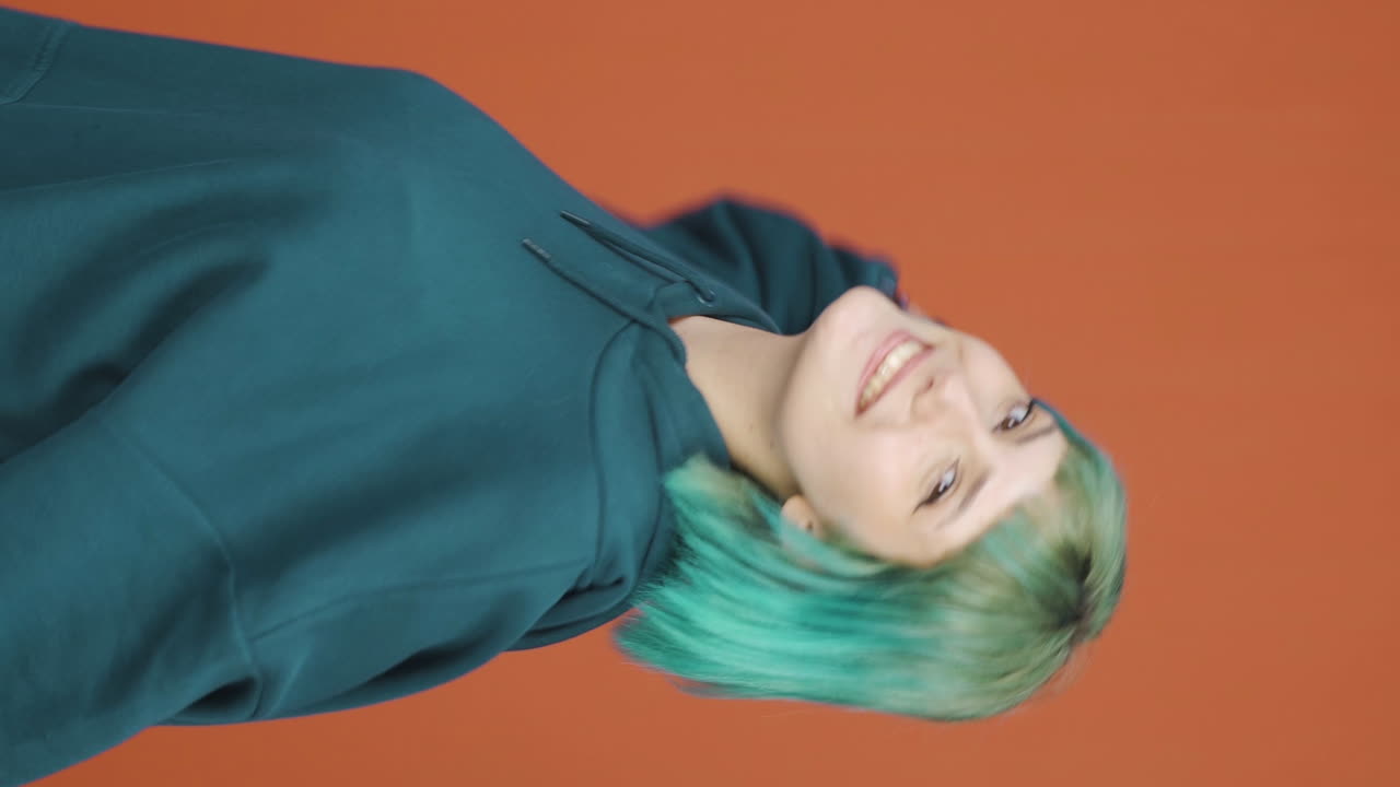 행복한 젊은 여성이 춤을 추는 수직 비디오.