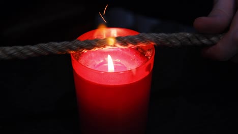 burning a jute rope on the fire of a candle for the shibari ritual