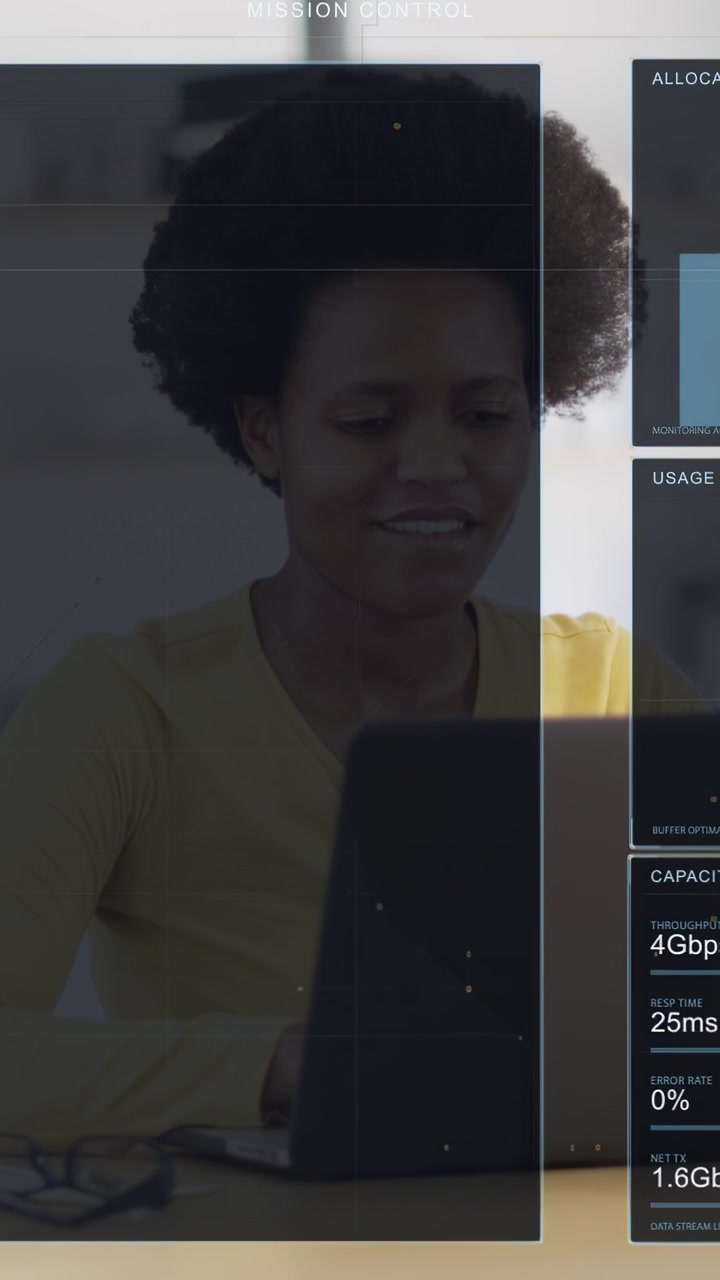 Vertical video: Woman typing on laptop, causing tech dashboard updating charts for monitoring data