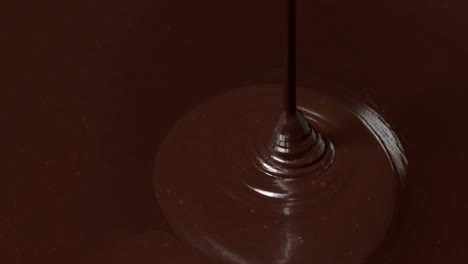 pouring melted liquid premium dark or milk chocolate with nuts, preparing confectionery dessert