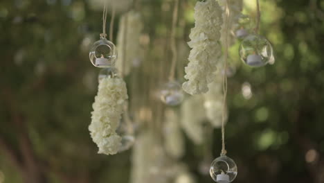 Burbujas-De-Velas-Colgantes-Con-Flores-Que-Soplan-En-El-Viento,-Tiro-Estático-De-Primer-Plano