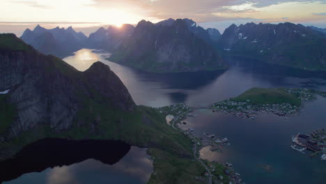 aerial forwarding shot of a hiker walking the famous peak reinebringen during midnight sun in lofoten