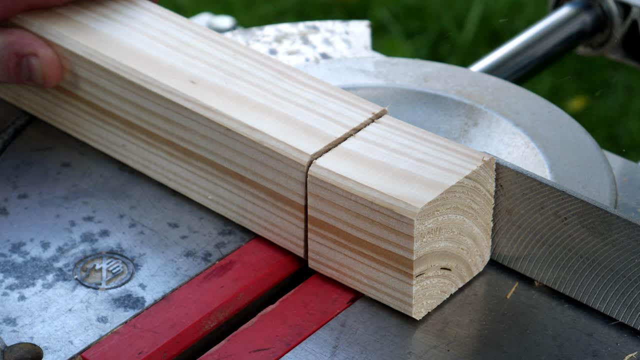 Footage of a circular saw that sawing through a piece of wood