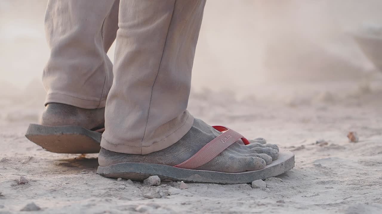 Close-up of feet in sandals covered in dust