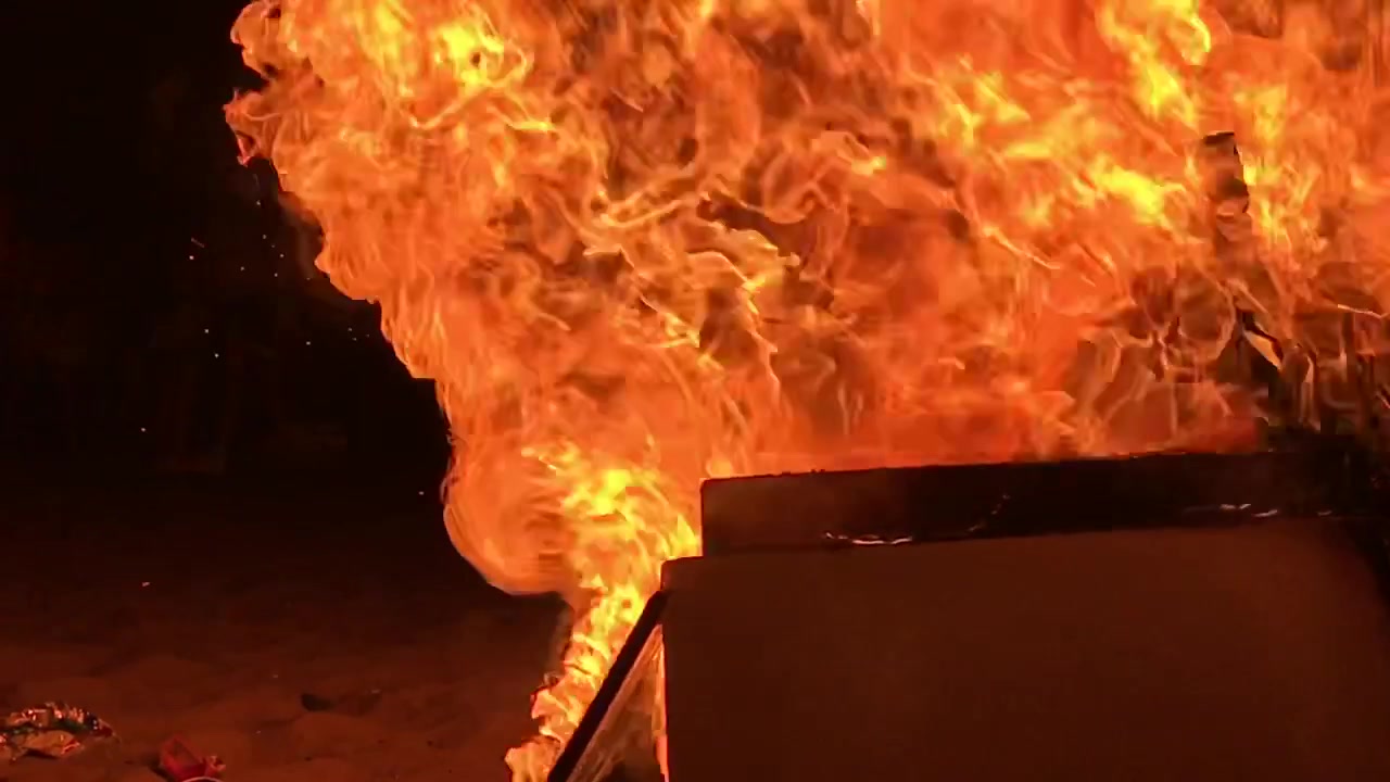 Celebrazione spagnola della notte dei falò di San Juan, grande falò sulla spiaggia. Filmato in slow motion, su una spiaggia a Marbella, Malaga, Spagna