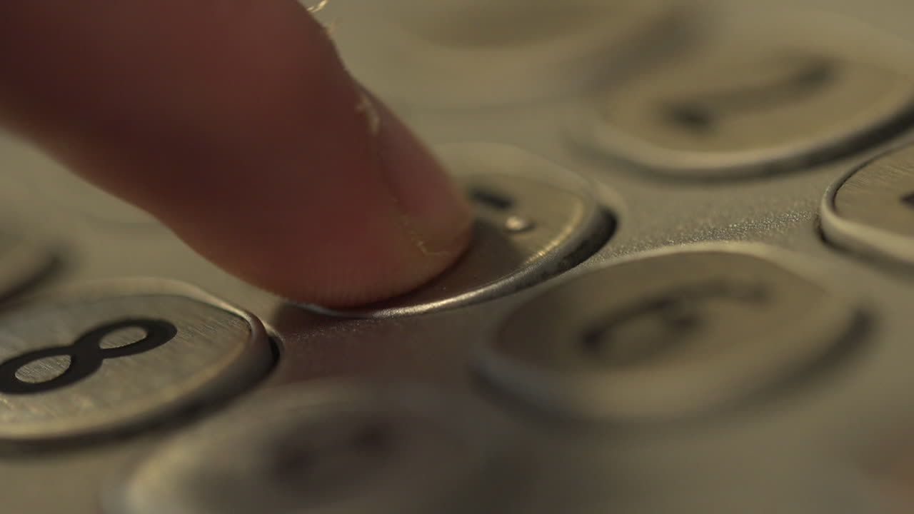 Finger pressing a button on a keypad