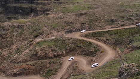 cuatro camiones de turismo descienden por un escarpado camino de tierra de sani pass off lesotho