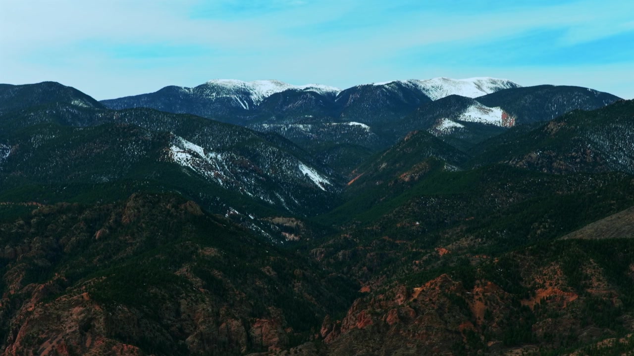 snow-covered Cheyenne Mountains Front Range Rocky Mountains landscape Colorado Springs Colorado aerial drone winter morning blue sky clouds Colorado's South of Denver's Broadmoor right circle