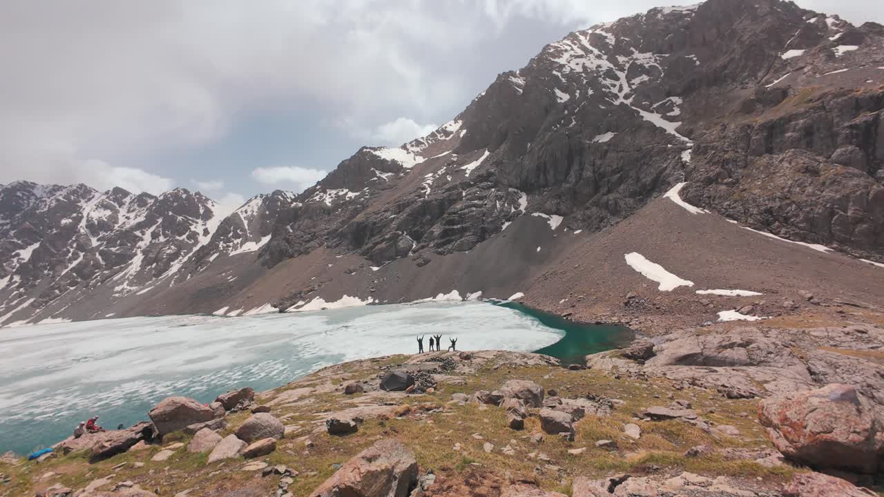 FPV cinematografico sulla superficie ghiacciata di Ala Kul, paesaggio remoto in vetta con cime aguzze e terreno alpino accidentato
