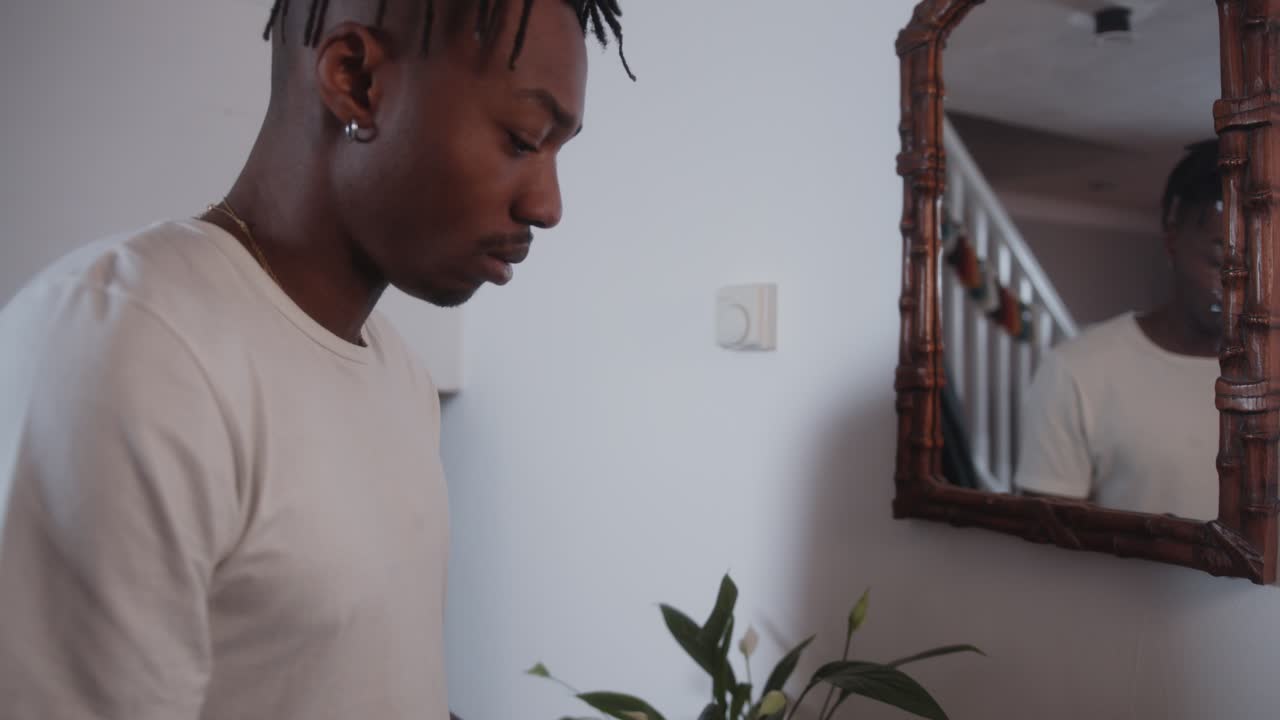Man adjusting modern home thermostat, lowering the temperature to save on energy bills during the cost of living crisis