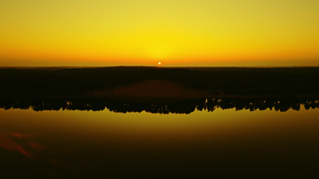 A Duna Branca da Letônia brilha em um nascer do sol dourado que se reflete no calmo rio Lielupe