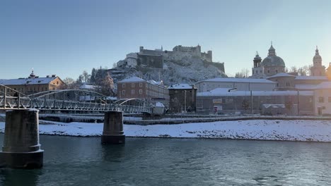 salzburg view of castle river and bridge covered in white snow on a sunny day