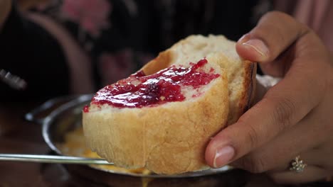 persona comiendo pan con mermelada