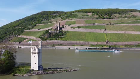 Carguero-Carguero-Barcaza-Navegando-Por-El-Río-Rin-Pasando-Por-La-Torre-De-Peaje-Y-El-Castillo-De-Ehrenfels,-Alemania