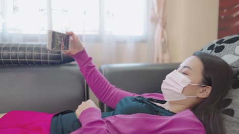 a close-up woman sitting on a sofa holding a smartphone for shopping online at home