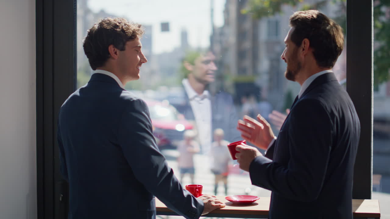 Happy businessmen coffee break at sunny city view panoramic window cafe closeup