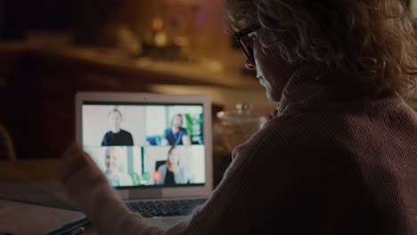 vista trasera de la mujer en videoconferencia con cuatro personas