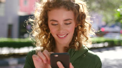 happy young woman texting on a phone in the city