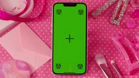 pink aesthetic flat lay with mobile phone and accessories