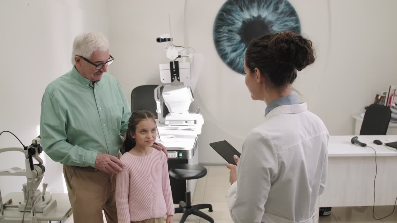 Senior Man And Little Girl At Oculist Appointment