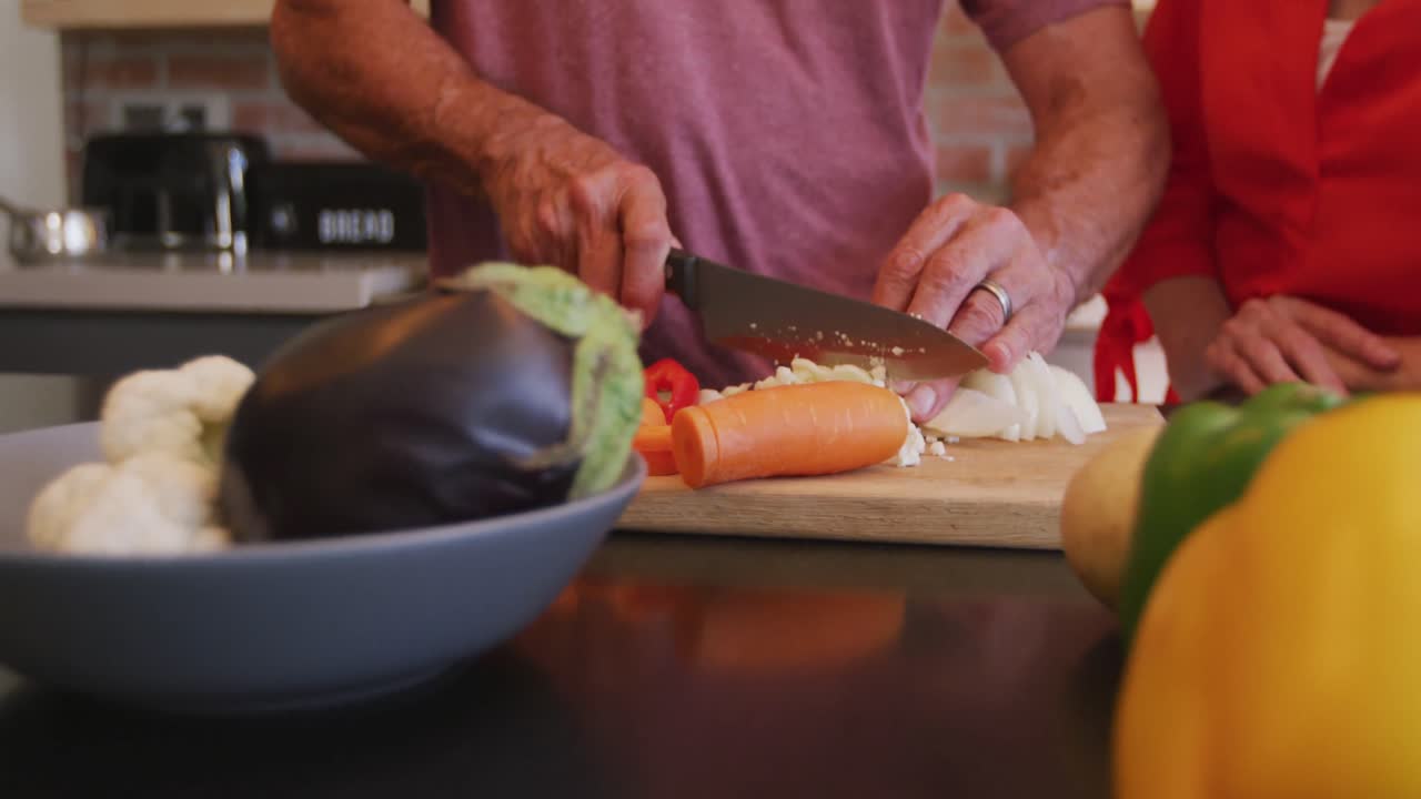 pareja caucásica de alto nivel cocinando juntos en la cocina