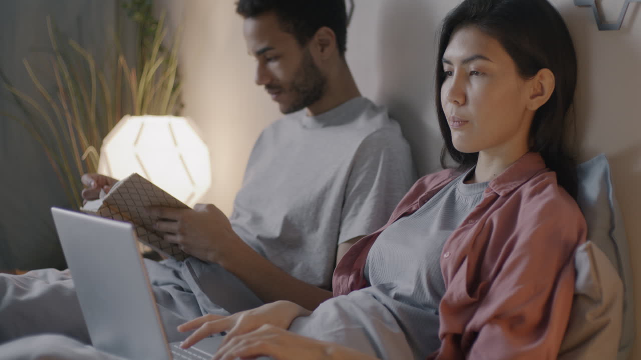 Couple Working in Bed at Night