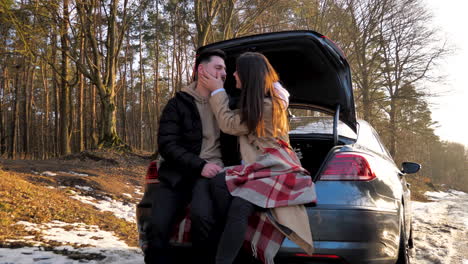 Caucasian-couple-cuddling-in-a-snowed-forest.