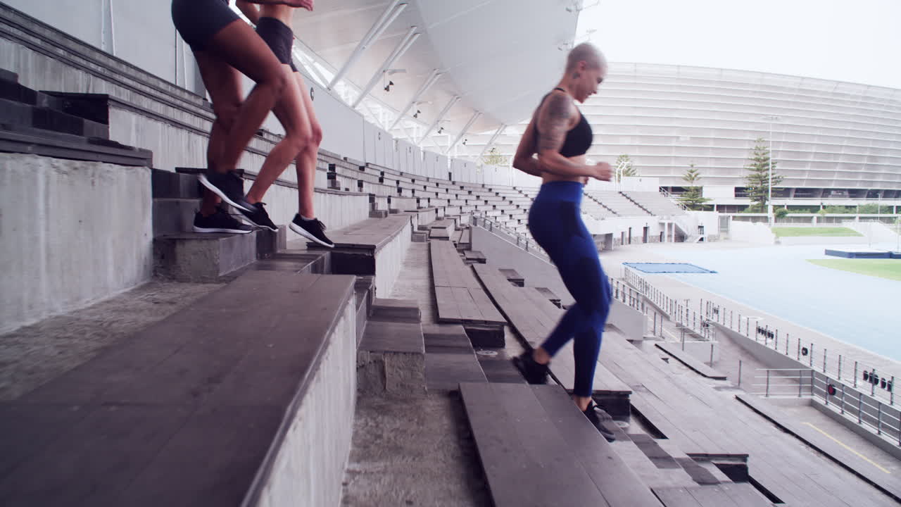 여자 운동 선수 들 이 경기장 에서 운동 하고 있다