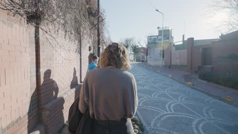 woman walking down a sunny city street