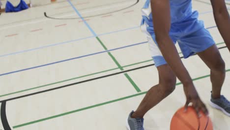 Porträt-Eines-Afroamerikanischen-Männlichen-Basketballspielers,-Der-In-Zeitlupe-Auf-Dem-Hallenplatz-Spielt