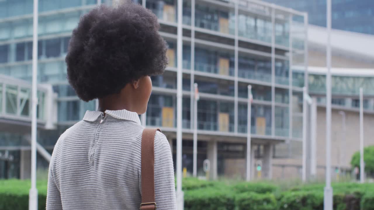 mujer de negocios afroamericana caminando por la ciudad
