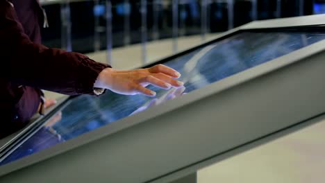 woman using interactive touchscreen display at modern history museum