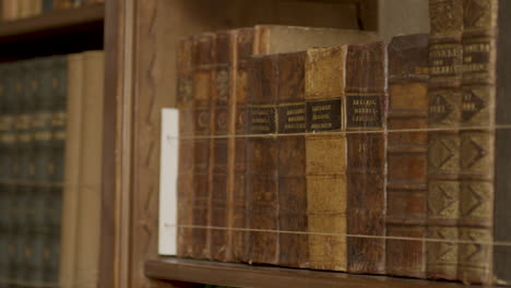 close pan over collection of old books in luxurious private library