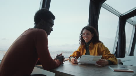 Diverse-Colleagues-Discussing-Business-Report-in-Rooftop-Office