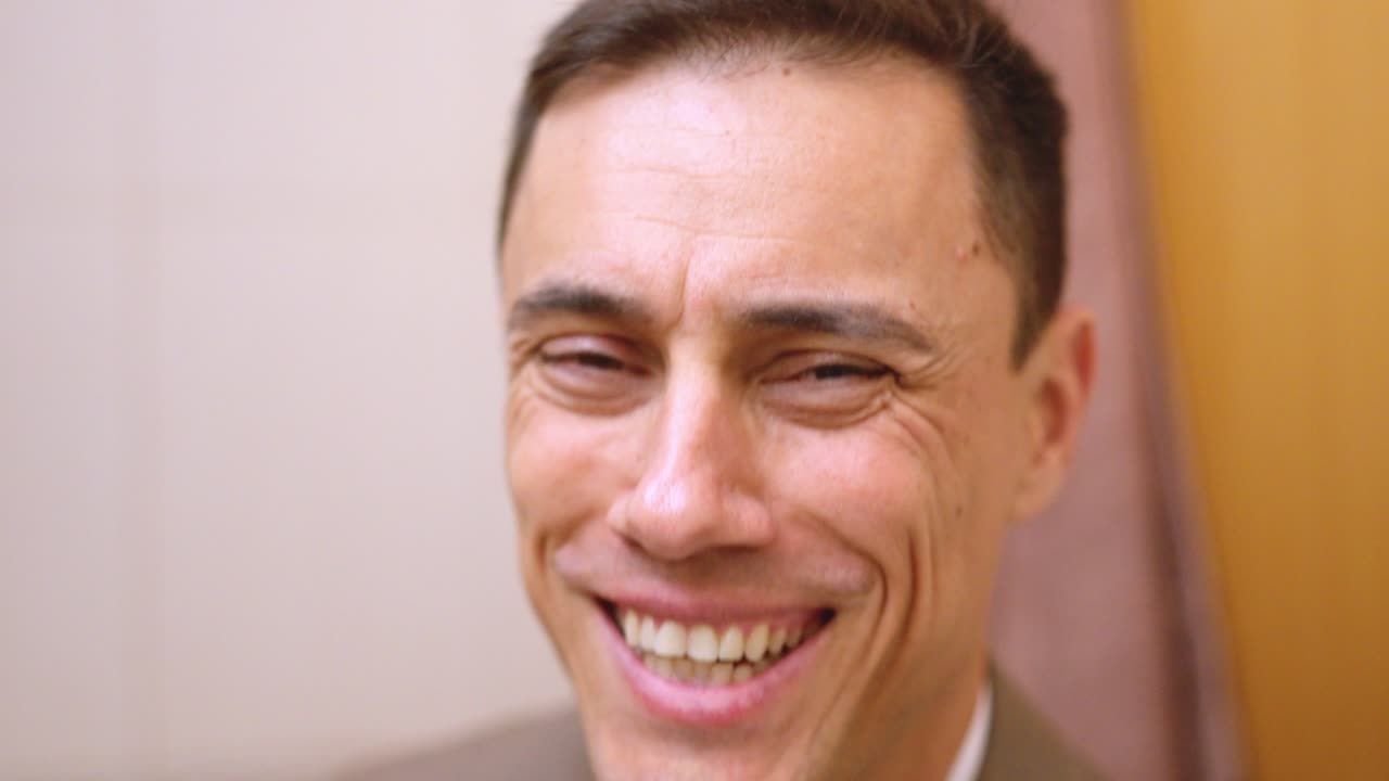 Successful businessman puts on his jacket in the bathroom