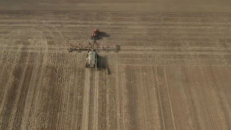 tractor de siembra trabajando en las vastas tierras de cultivo en saskatchewan, canadá, en una mañana soleada - disparo de drones estáticos