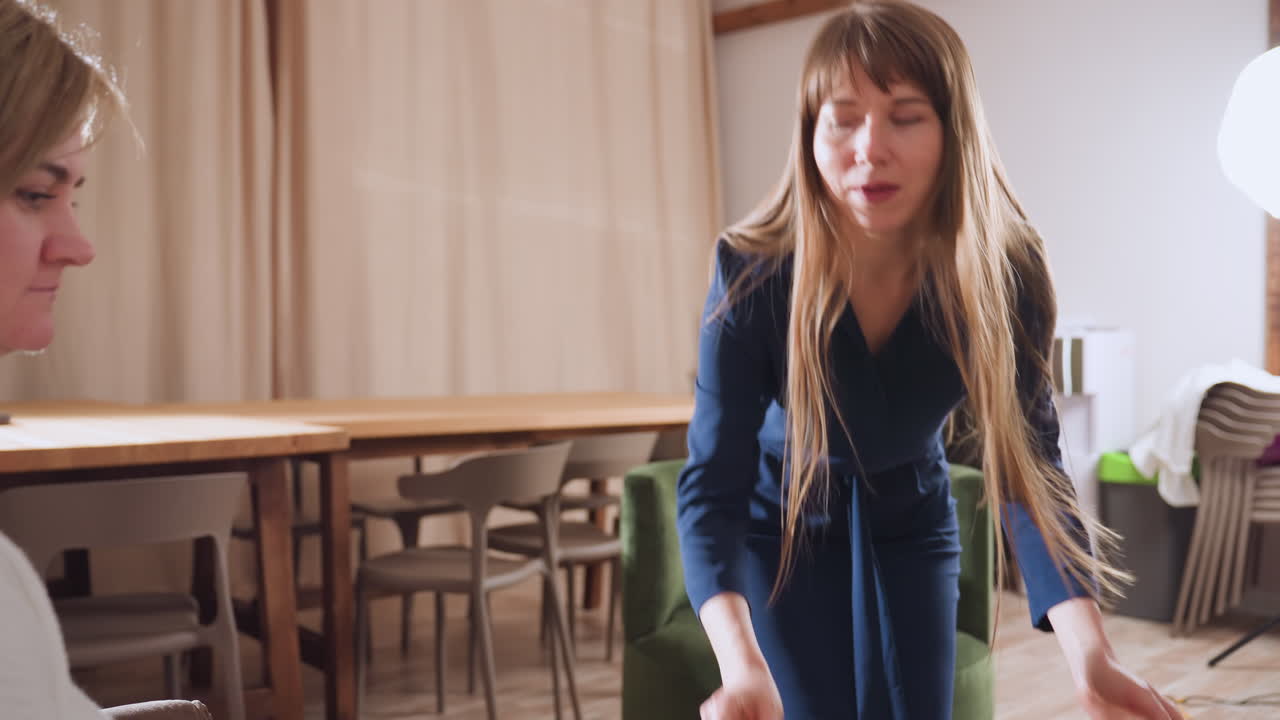 Wellness guide carrying tray walks to patient seated in cozy therapy room with warm smiles offering clay on tray guiding patient to mold clay fostering creative healing through tactile art activity