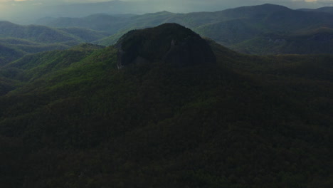 aerial panning to reveal looking glass rock towering over asheville nc forest