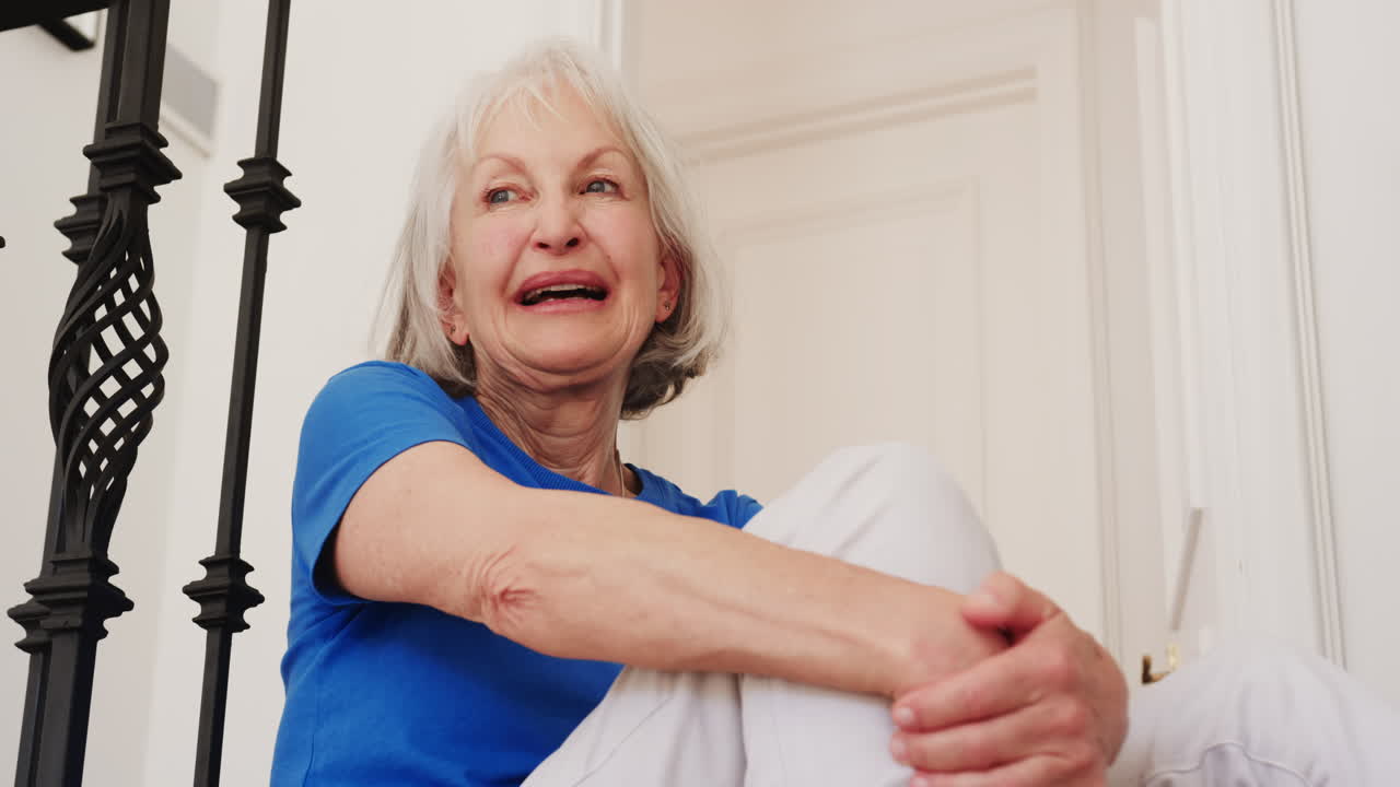 Senior woman sitting at home, reading book and sipping tea peacefully