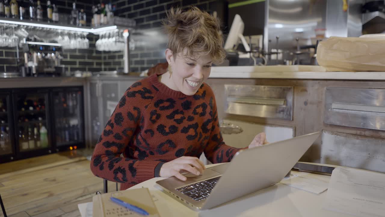 mujer trabajando en una computadora portátil en un café
