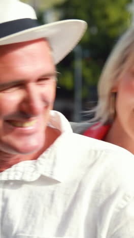 smiling couple sitting on a scooter