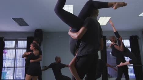 mixed race fit male and female modern dancers practicing a dance routine