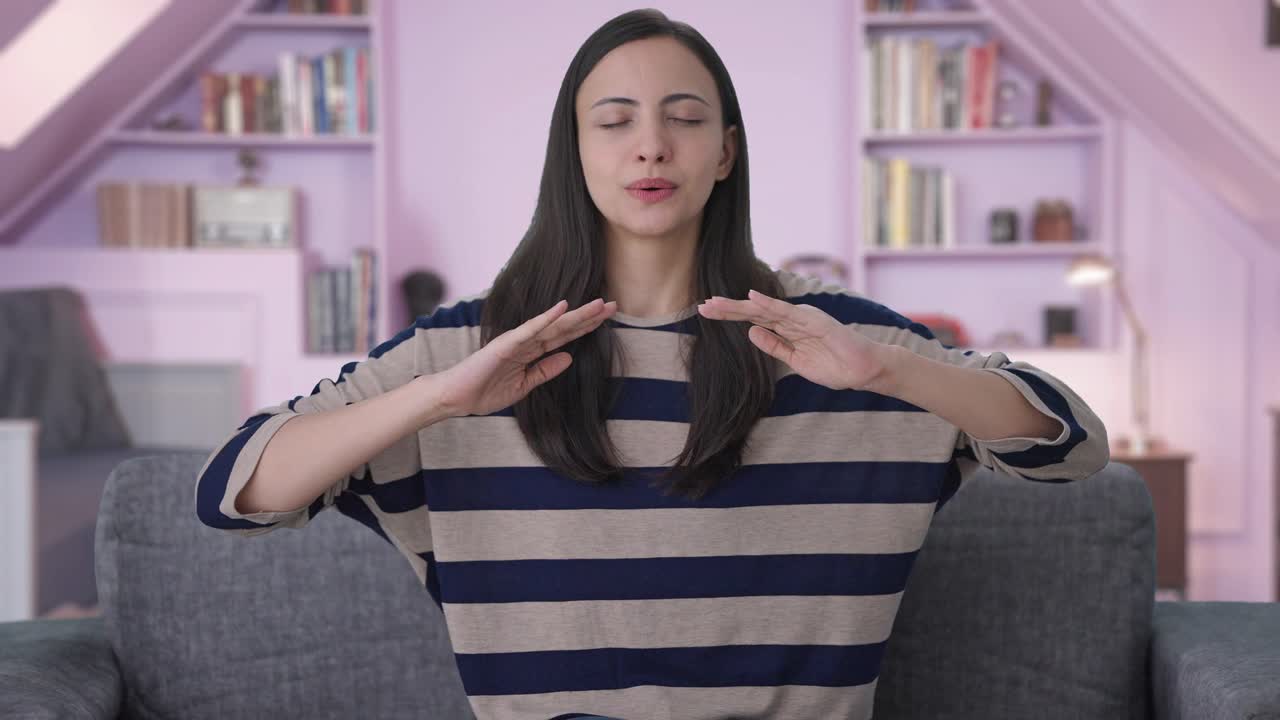 chica india feliz haciendo ejercicio de inhalación y exhalación