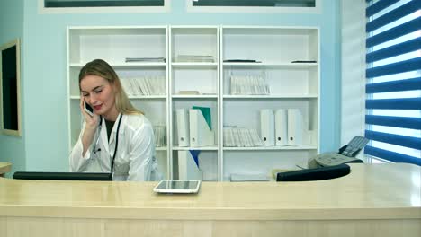 female nurse at hospital reception answering phone calls and scheduling patient appointments