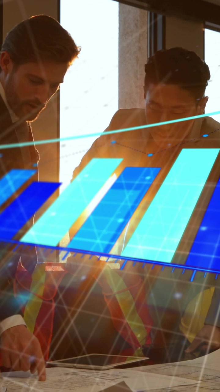 Vertical video: Two men leaning on site plans, blue chart sweeping causing tracing with orange pen