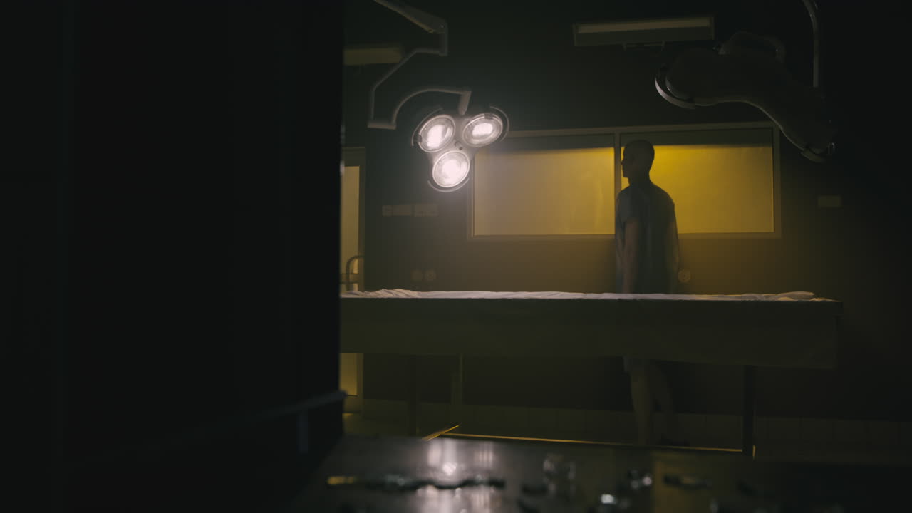 A bald man looks through the yellow glass in the operation room