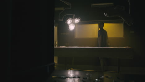 a bald man looks through the yellow glass in the operation room
