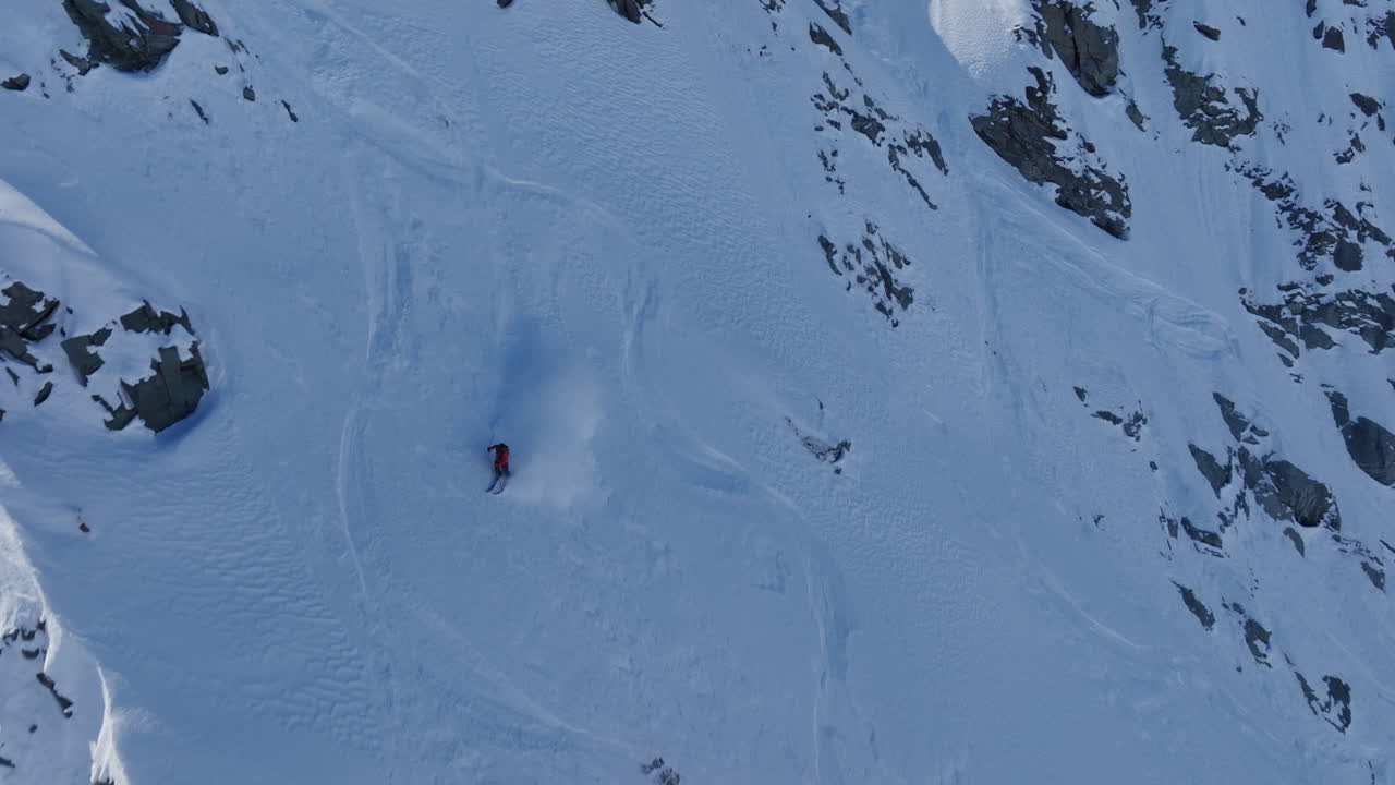 A professional skier hikes up a steep ridge in Verbier, then drops into an epic freeride descent. Pure adventure skiing in deep snow, dramatic terrain, and breathtaking alpine scenery.